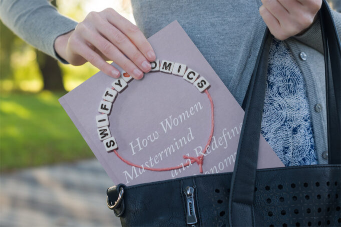 Breaking News Alert Kansas A woman's hand pulls the book "Swiftynomics" from a handbag.